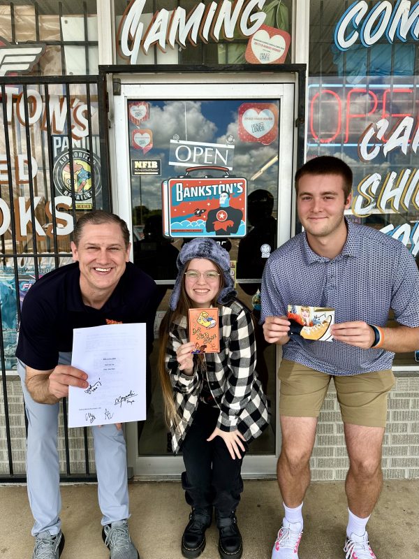 The team at Bankston's Comics at Waco, TX with merchandise of Chen Drachman's But I'm a Shoe, signed by Janet Varney.